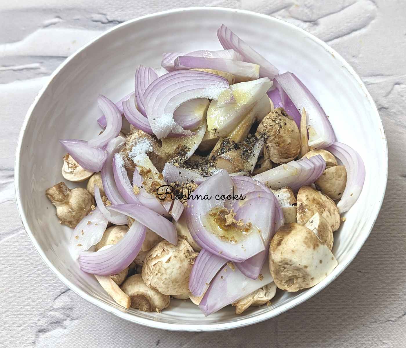 Mushroom an onion with oil and spices in a bowl