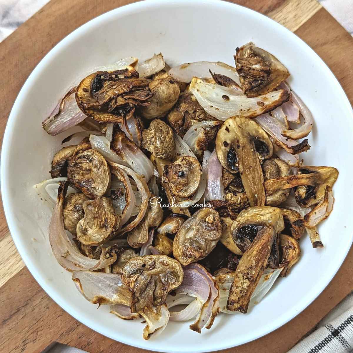 Air fried mushroom and onion in a white plate.