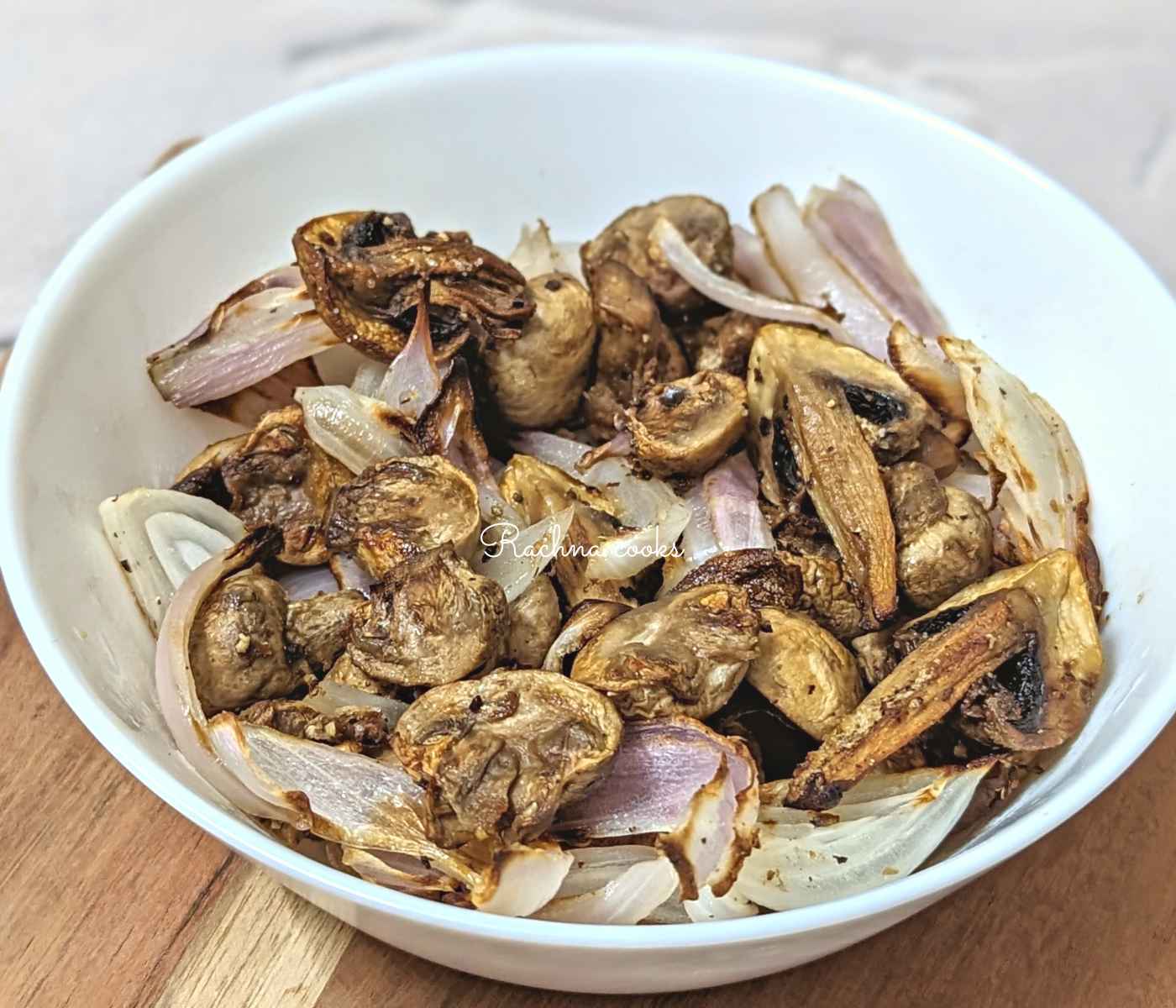 Air fryer mushroom and onion in a white bowl.