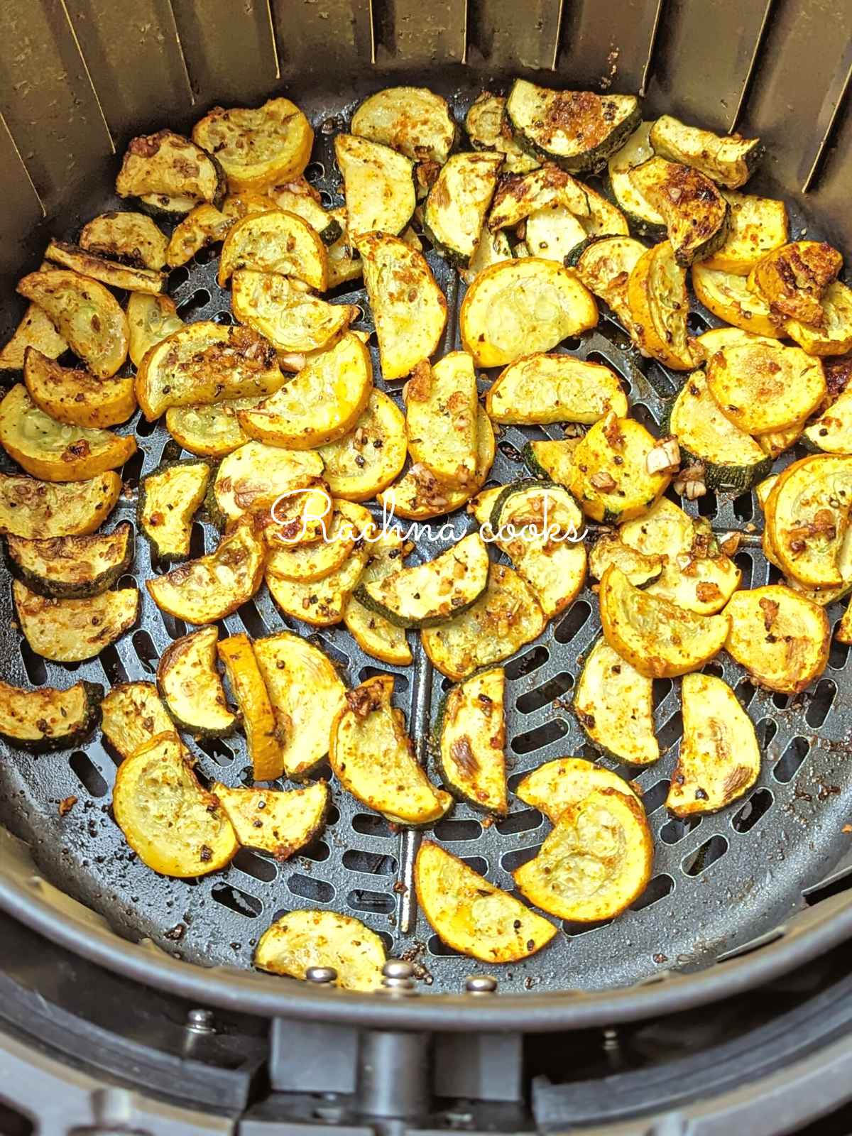 Air fried zucchini and squash in air fryer basket.