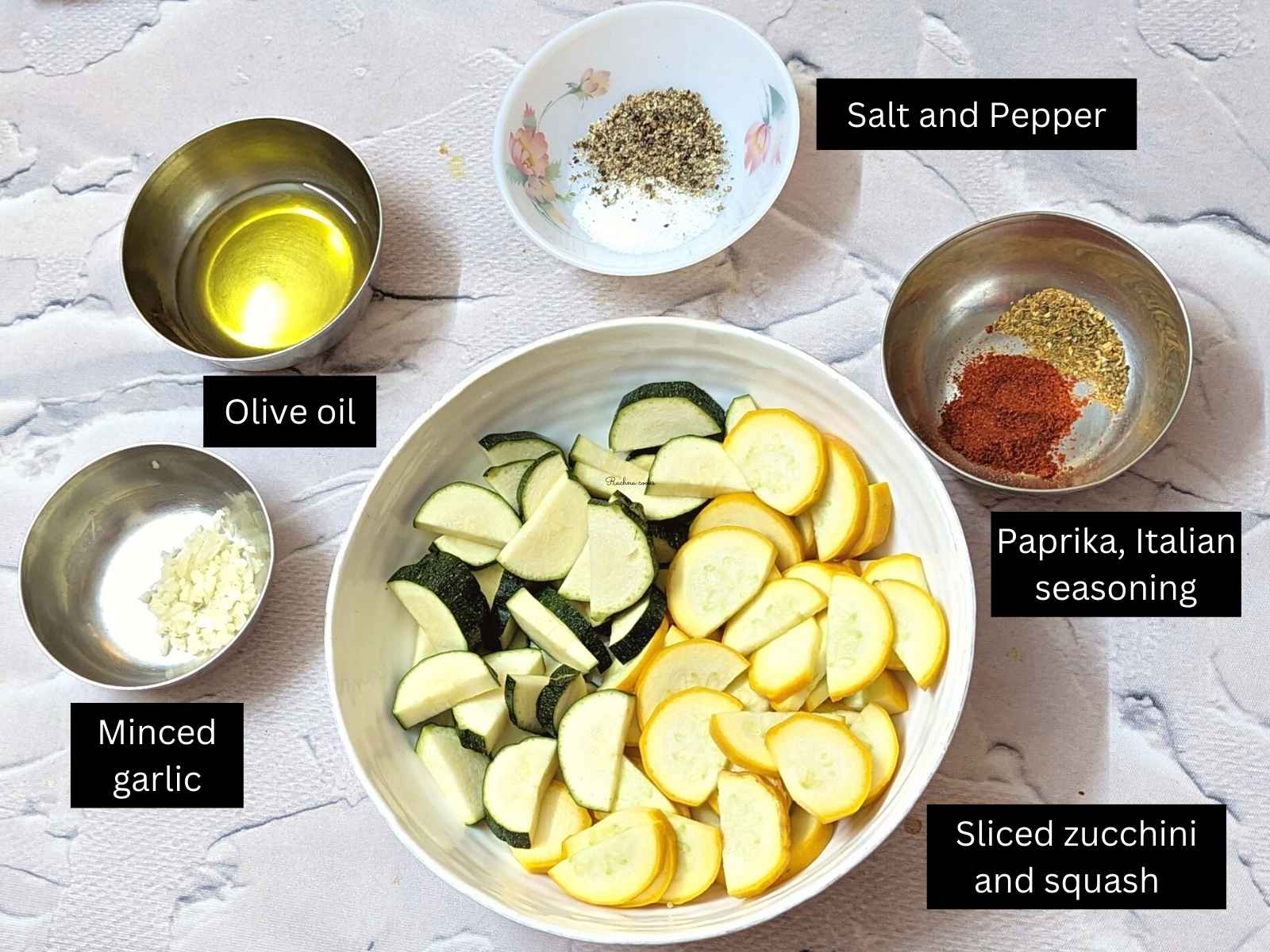 Ingredients for making air fryer zucchini: sliced zucchini and squash, olive oil, seasonings, minced garlic and lemon juice