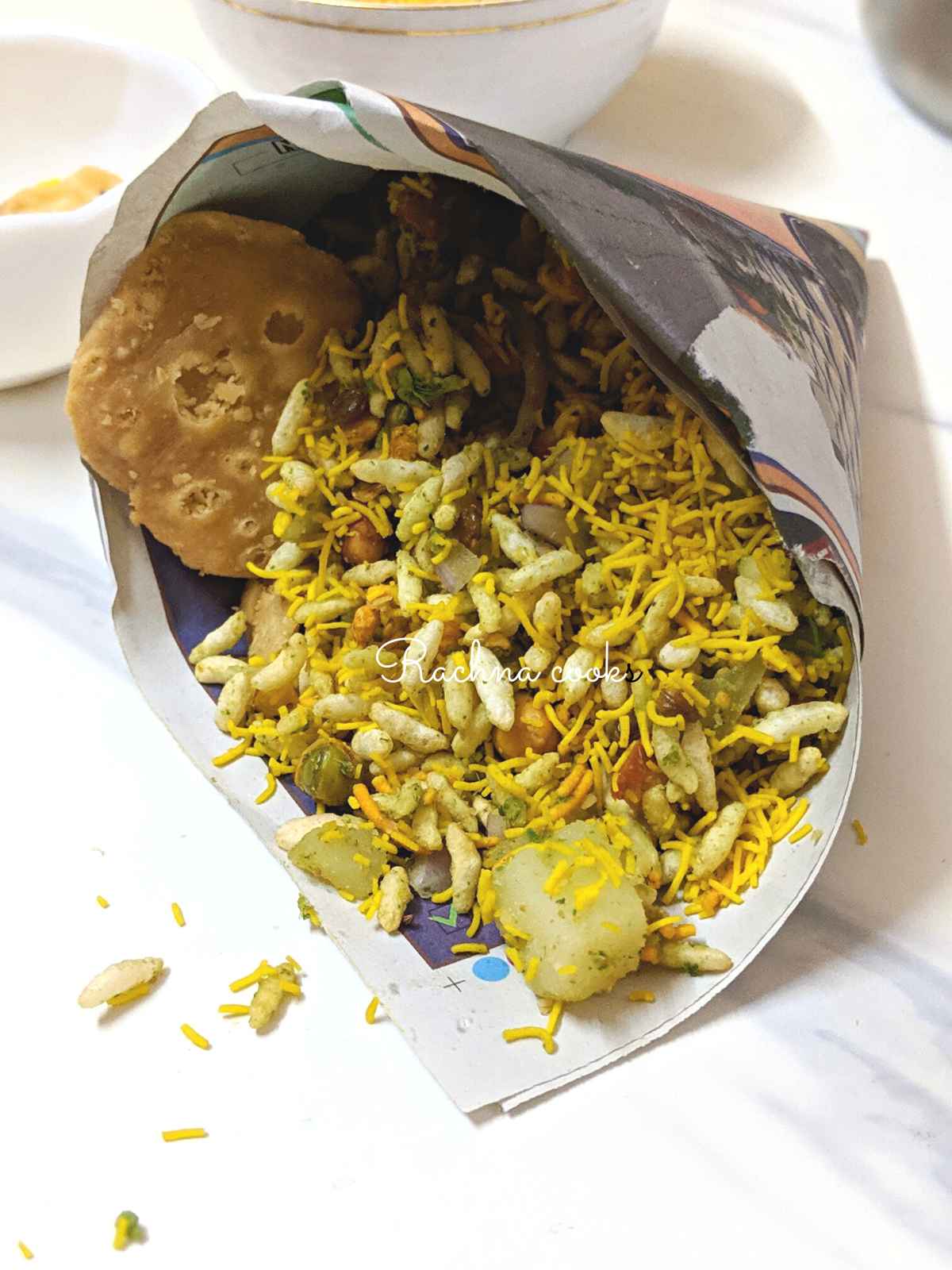 Bhelpuri served in a paper cone with papri visible.