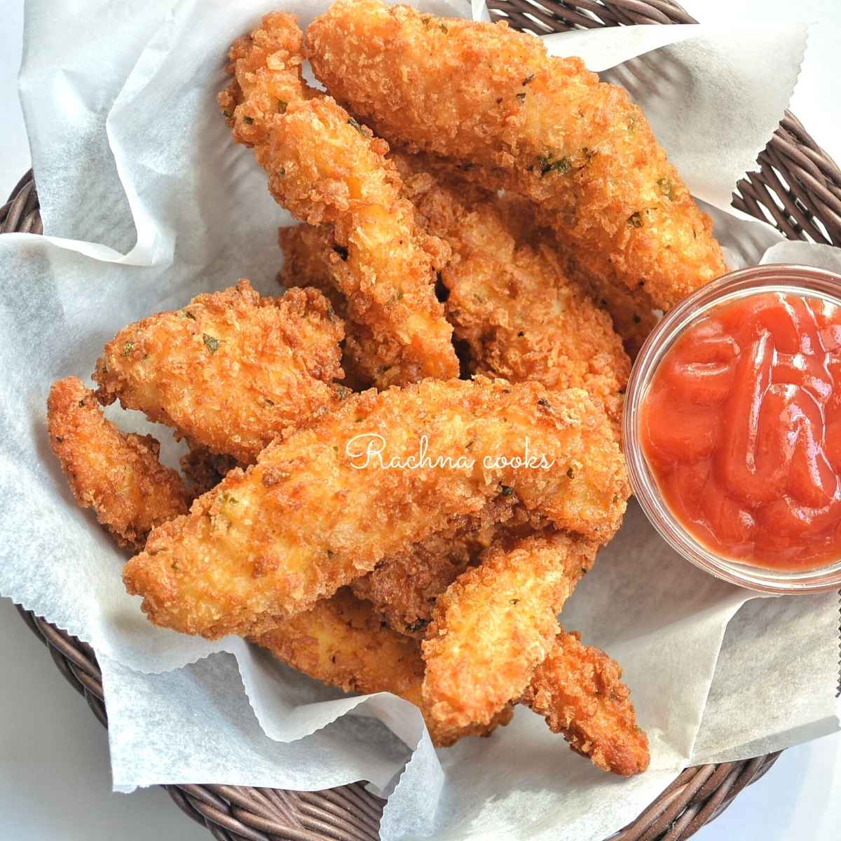 crunchy chicken tenders in a basket with a side of ketchup