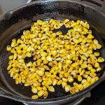 A skillet full of charred corn
