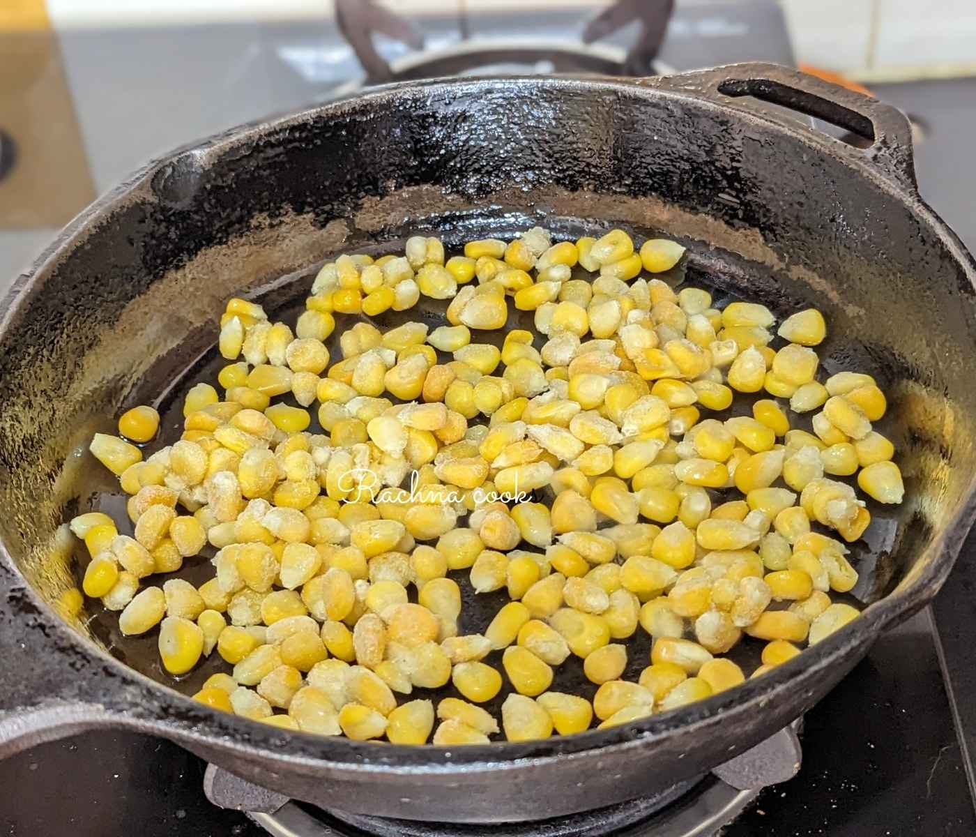 Frozen corn spread out in a hot skillet