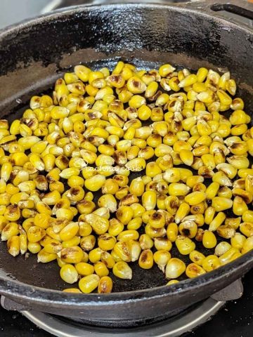 A skillet filled with charred corn