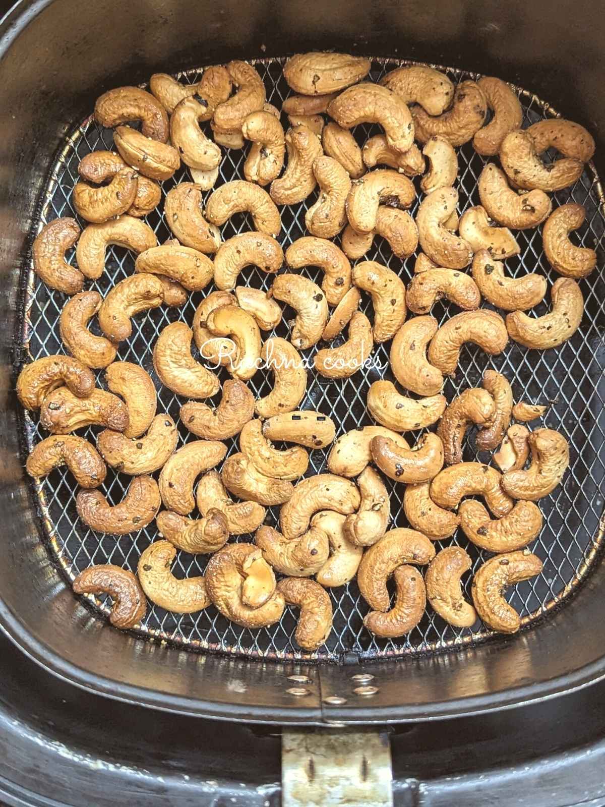 Air fried cashewnuts in air fryer basket.