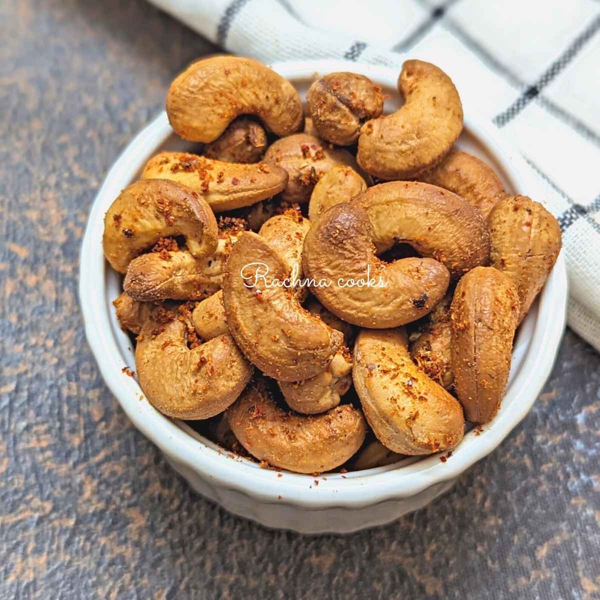 Golden roasted air fryer cashews in a white bowl.