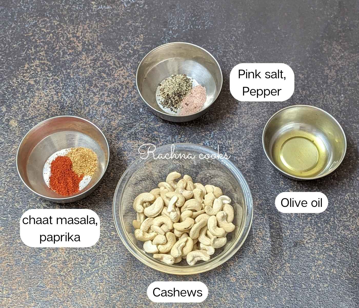Ingredients for making roasted cashews in air fryer. seasonings, oil and cashews in bowls.