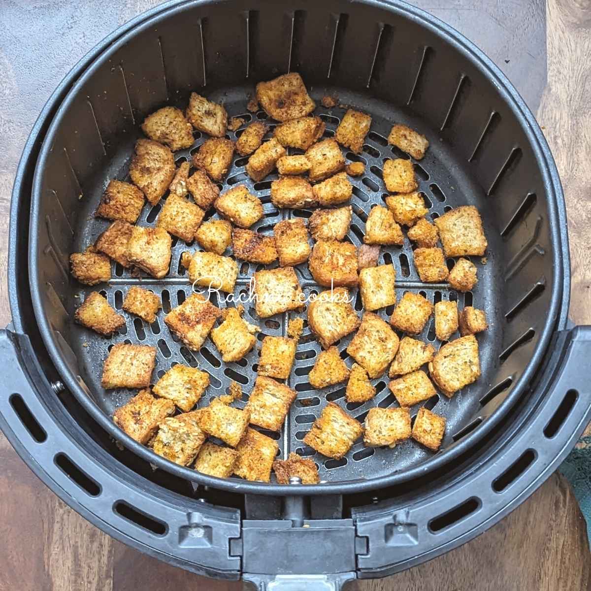 golden crispy air fryer croutons in air fryer basket.