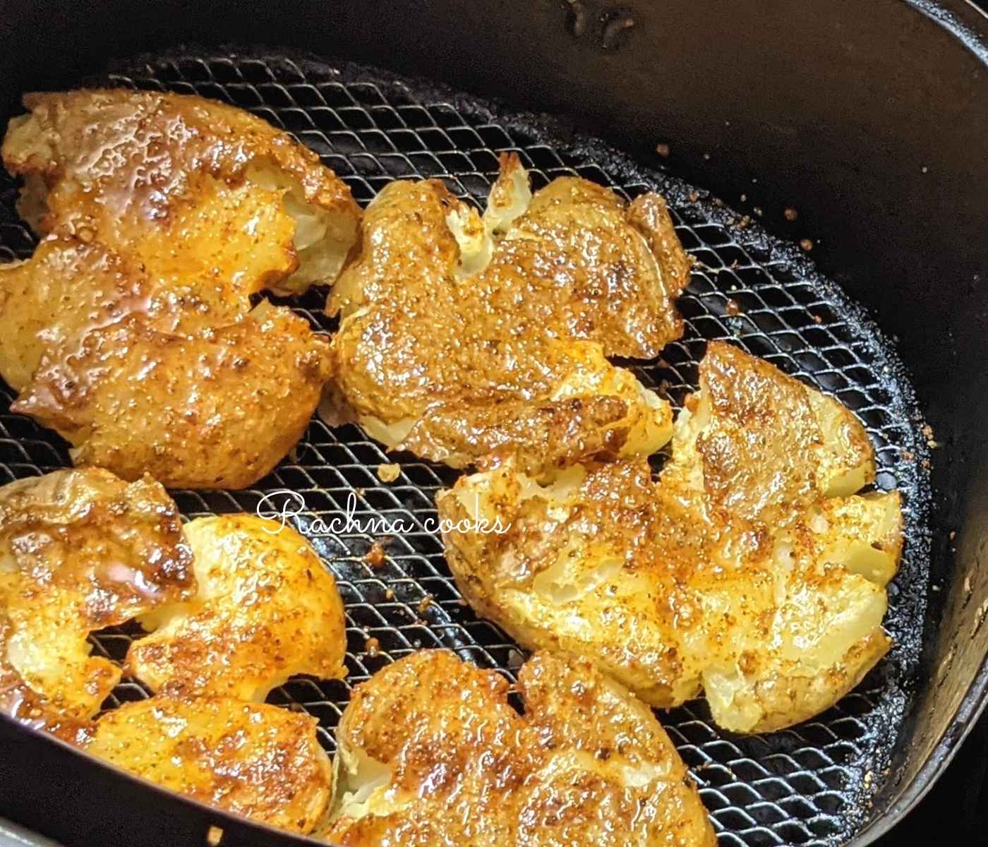 Air fryer smashed potatoes in air fryer basket.