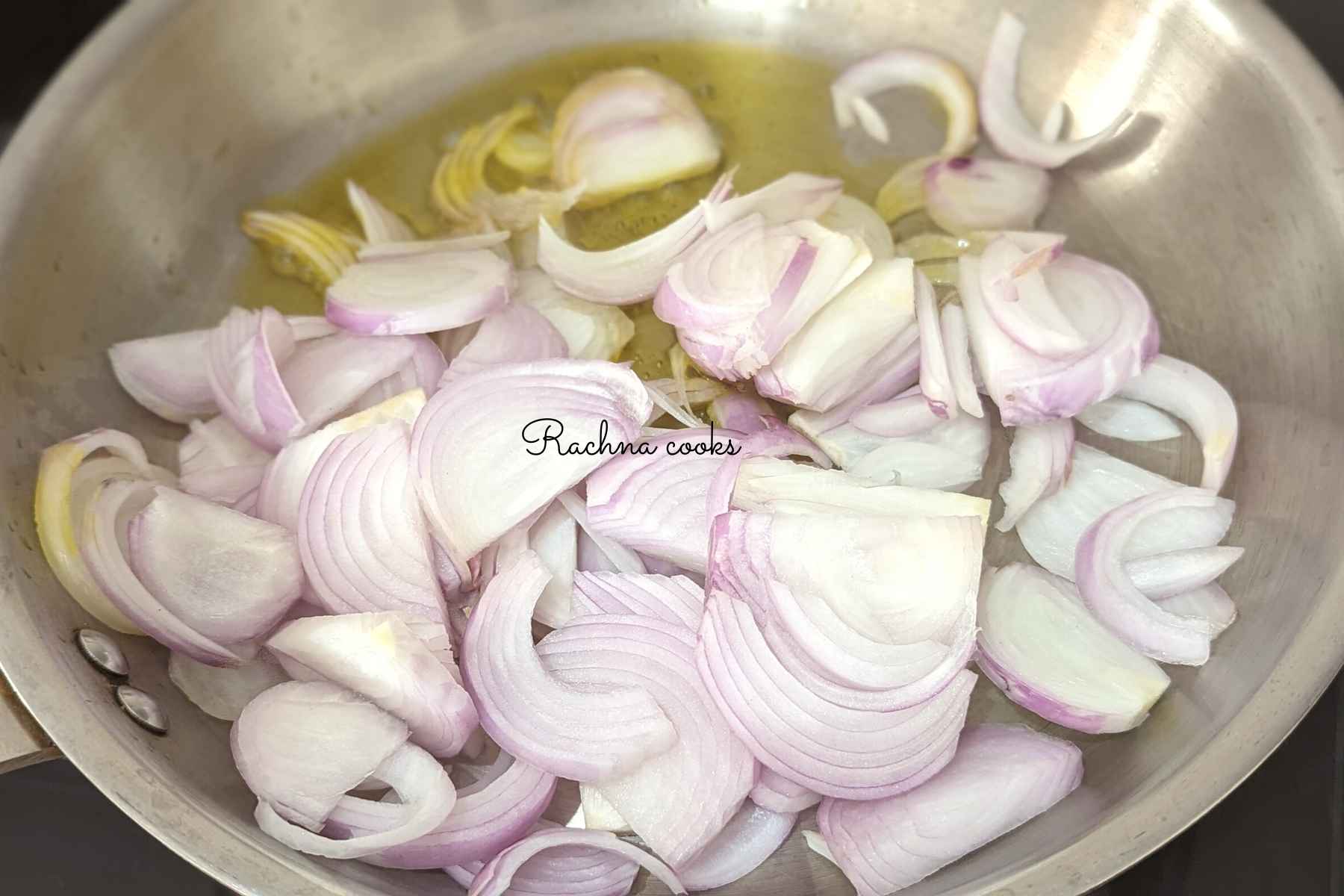 Finely sliced onions added to oil in a pan.