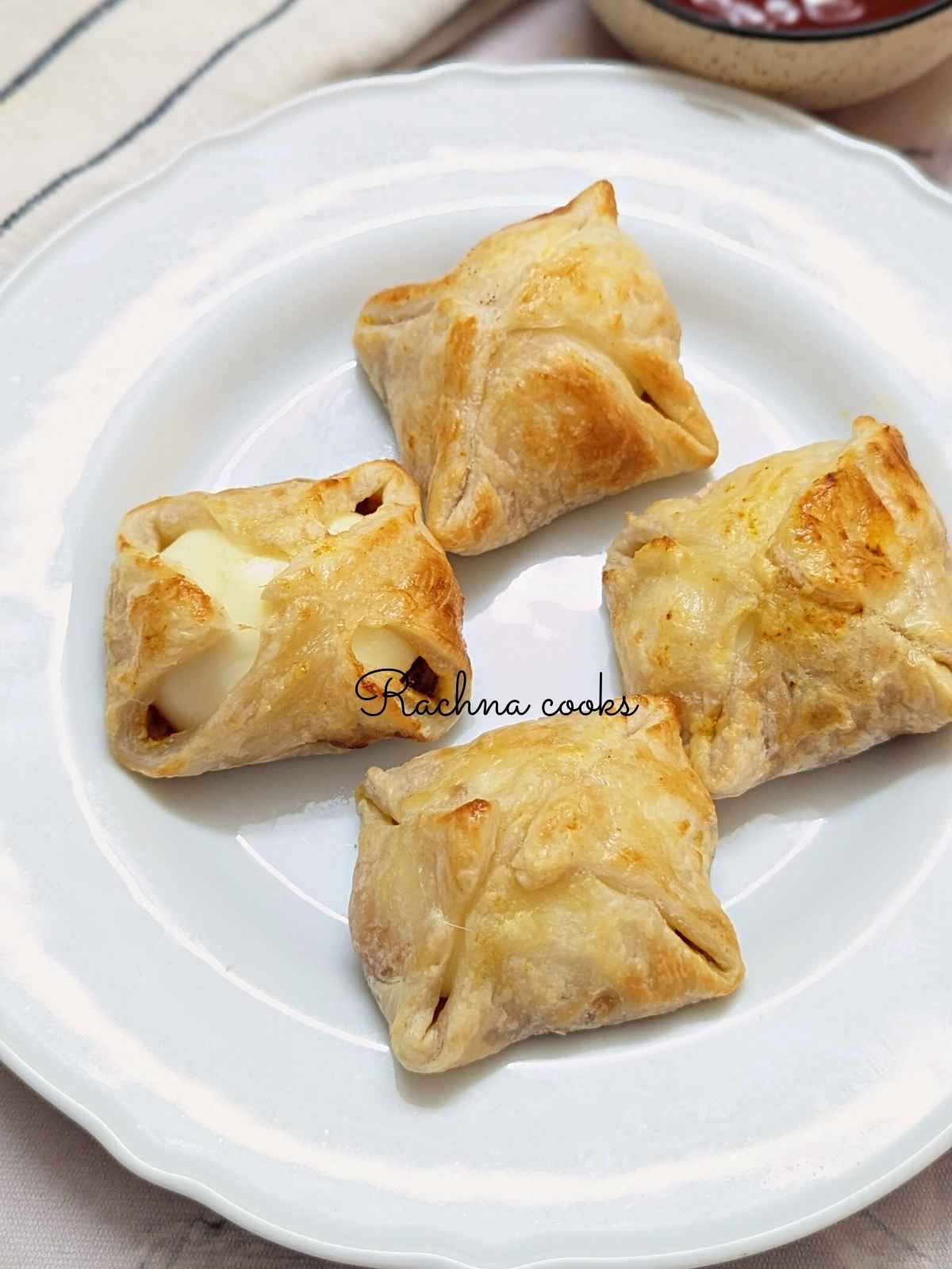 4 egg puffs served on a white plate.