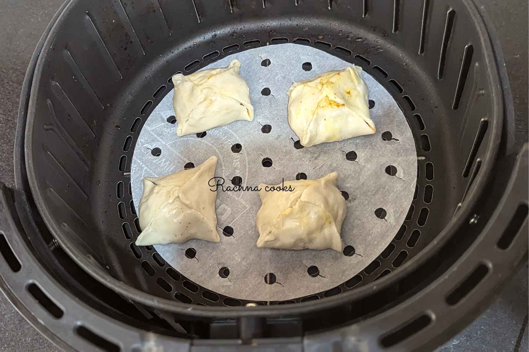 4 egg puffs in air fryer basket ready for air frying.