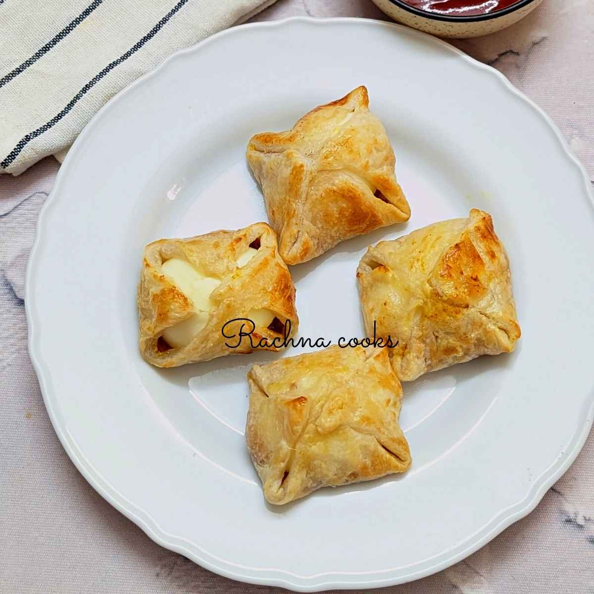 4 golden egg puffs on a white plate