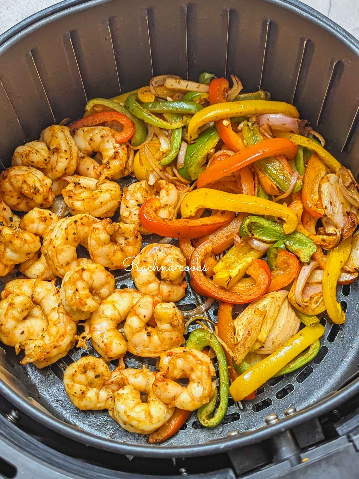 Cooked shrimp and veggies in air fryer basket