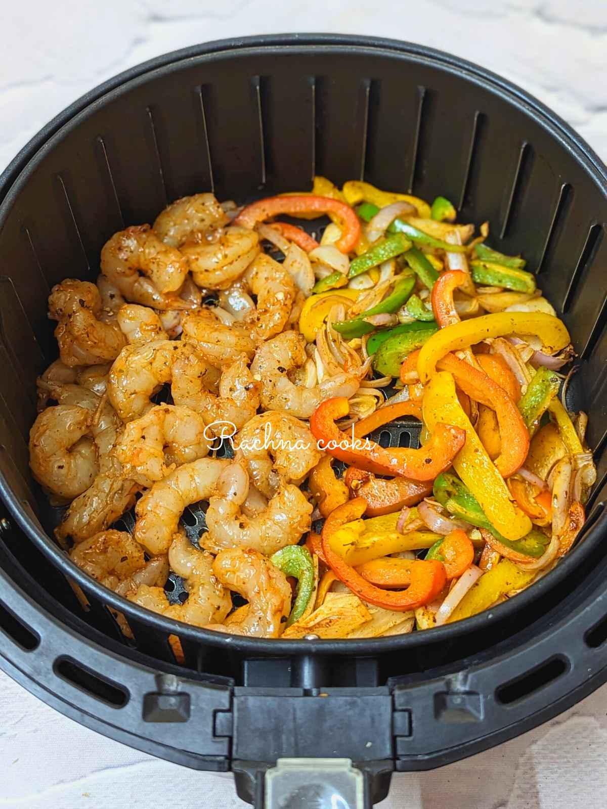 Seasoned shrimp added to half cooked veggies in air fryer basket
