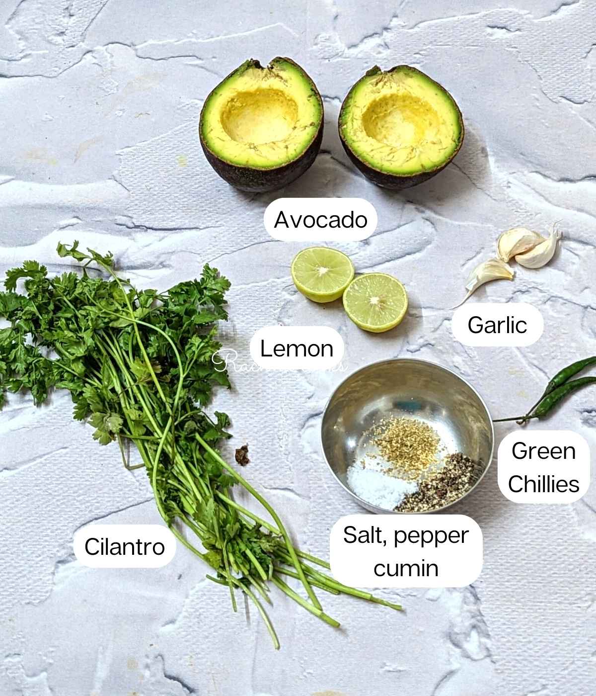 Ingredients for avocado chutney: cut avocado, cilantro, chillies, garlic, lemon salt and seasonings.