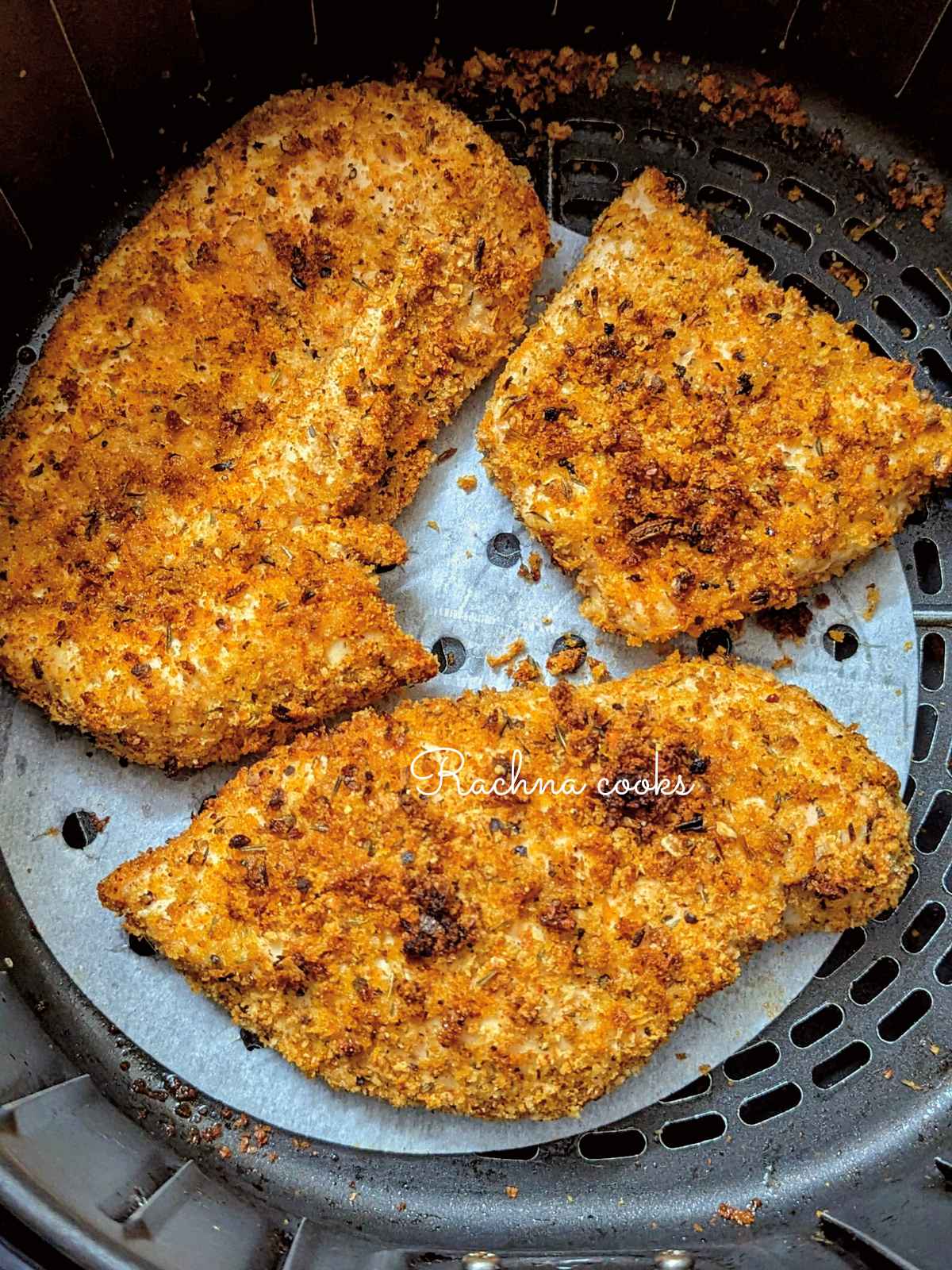3 shake and bake chicken breasts after air frying placed in air fryer basket.