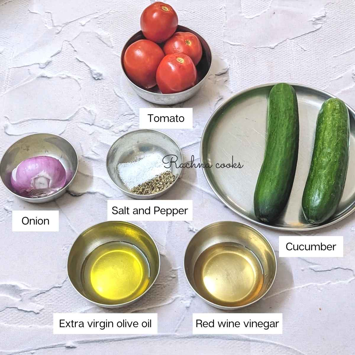 Ingredients for making Mediterranean cucumber tomato salad. Cucumbers, tomatoes, onion, extra virgin olive oil, red wine vinegar, salt and pepper