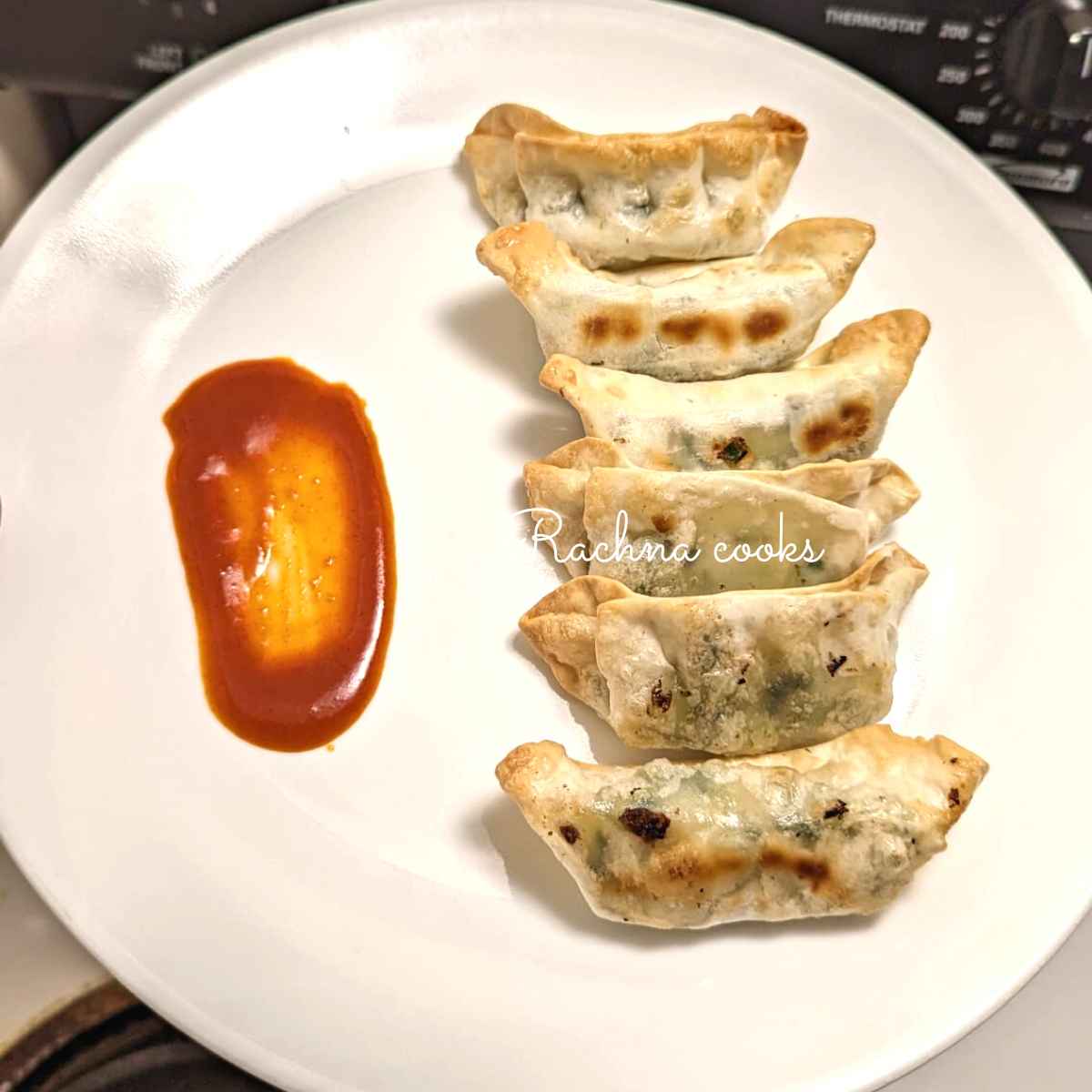 Gyozas or potstickers after air frying served on a white plate.