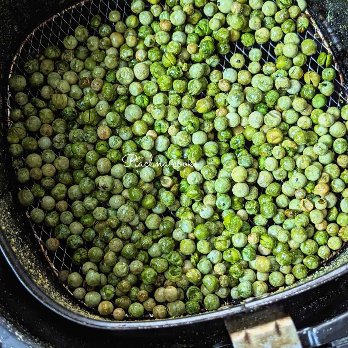 Crispy green peas after air frying in air fryer basket.