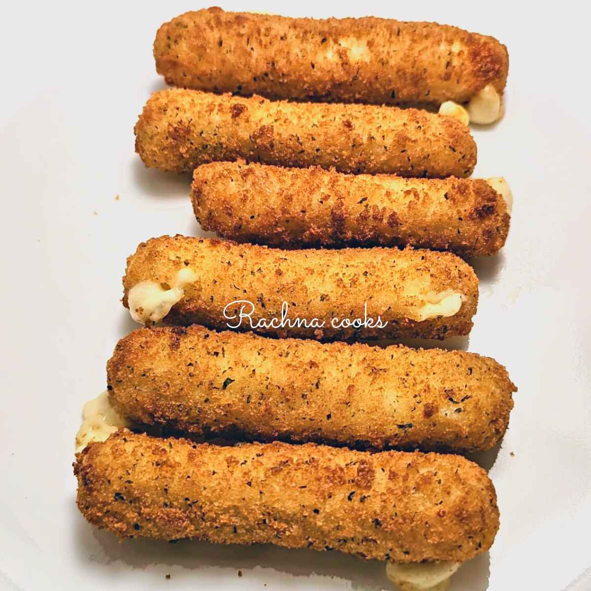 Crispy air fried mozzarella sticks served on a white plate