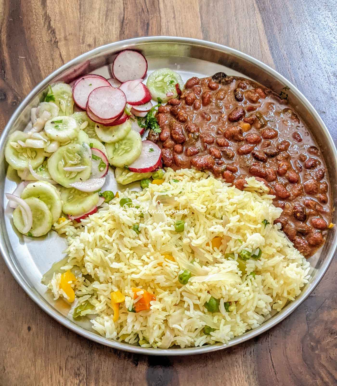 Vegetable pulao served with rajma curry and salad.