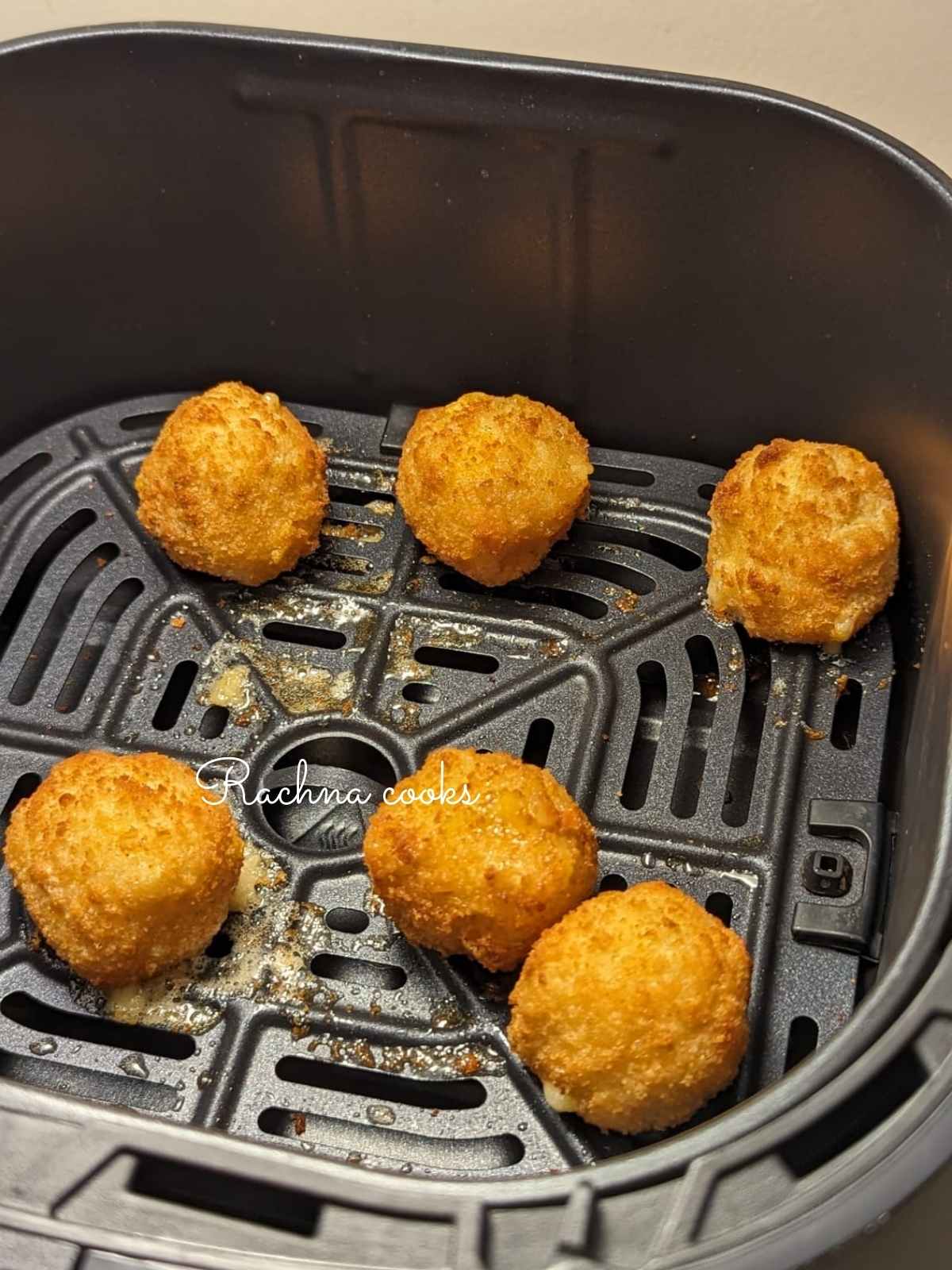 6 mac and cheese bites in air fryer basket.