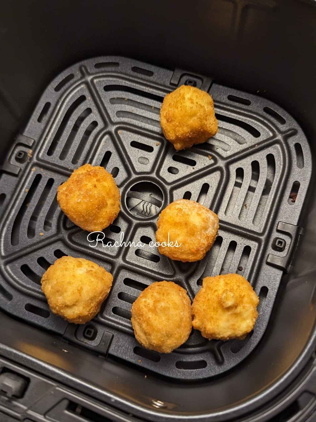 Frozen mac and cheese bites placed in air fryer basket