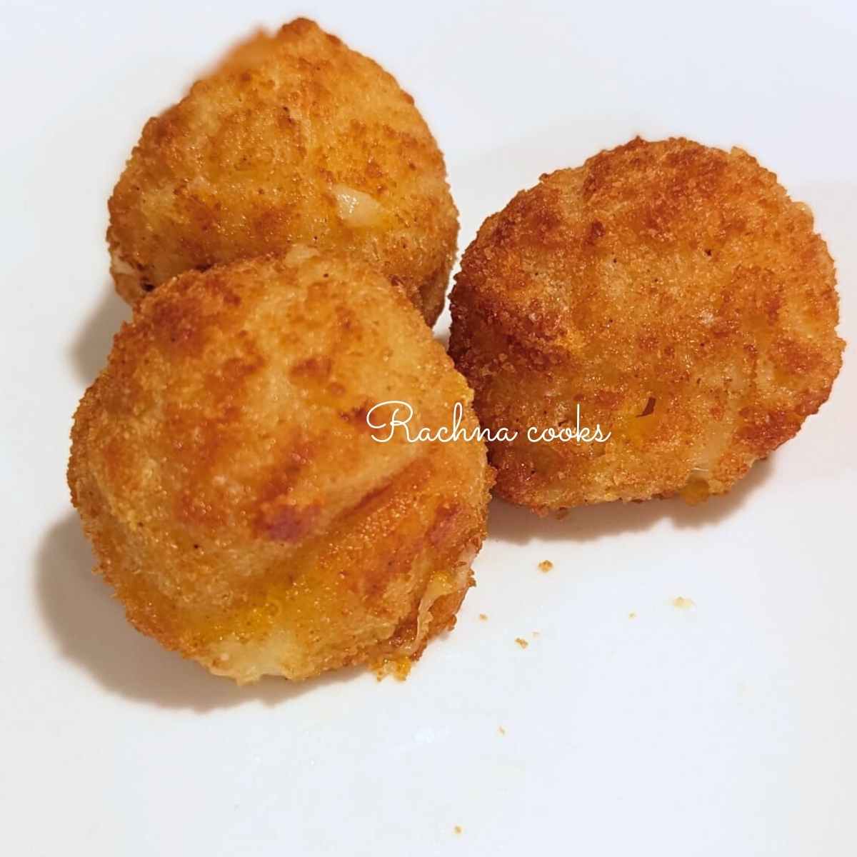3 air fried mac and cheese bites on a white plate.