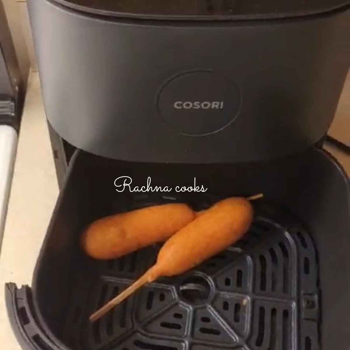 2  corn dogs placed in air fryer basket .