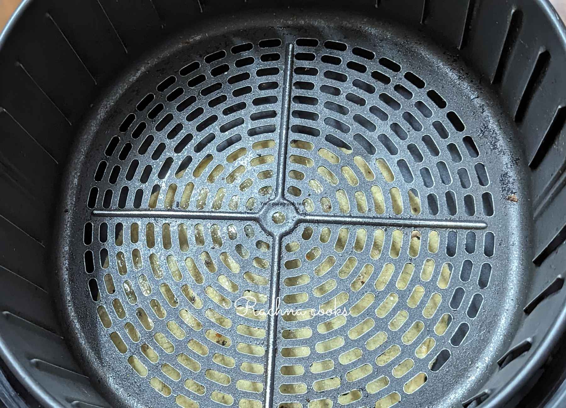Air fryer basket closed with papad placed below