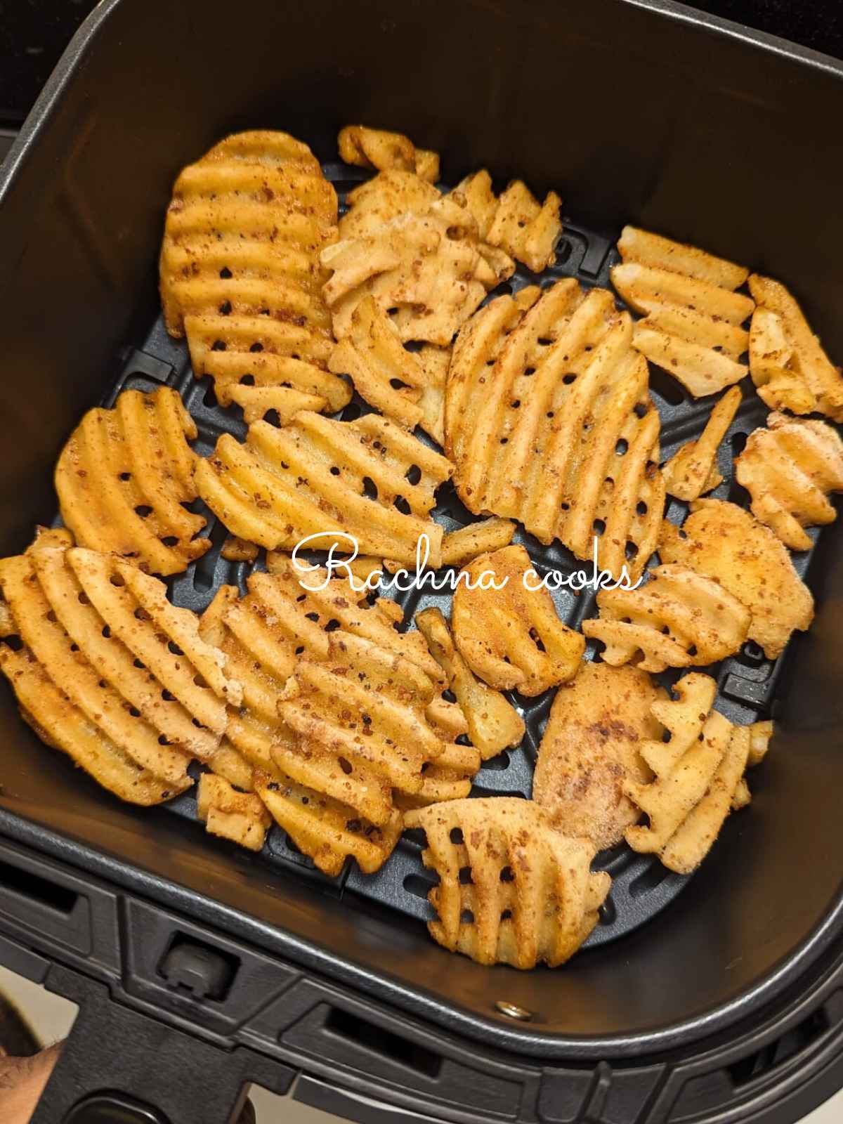 Frozen waffle fries placed in air fryer basket.