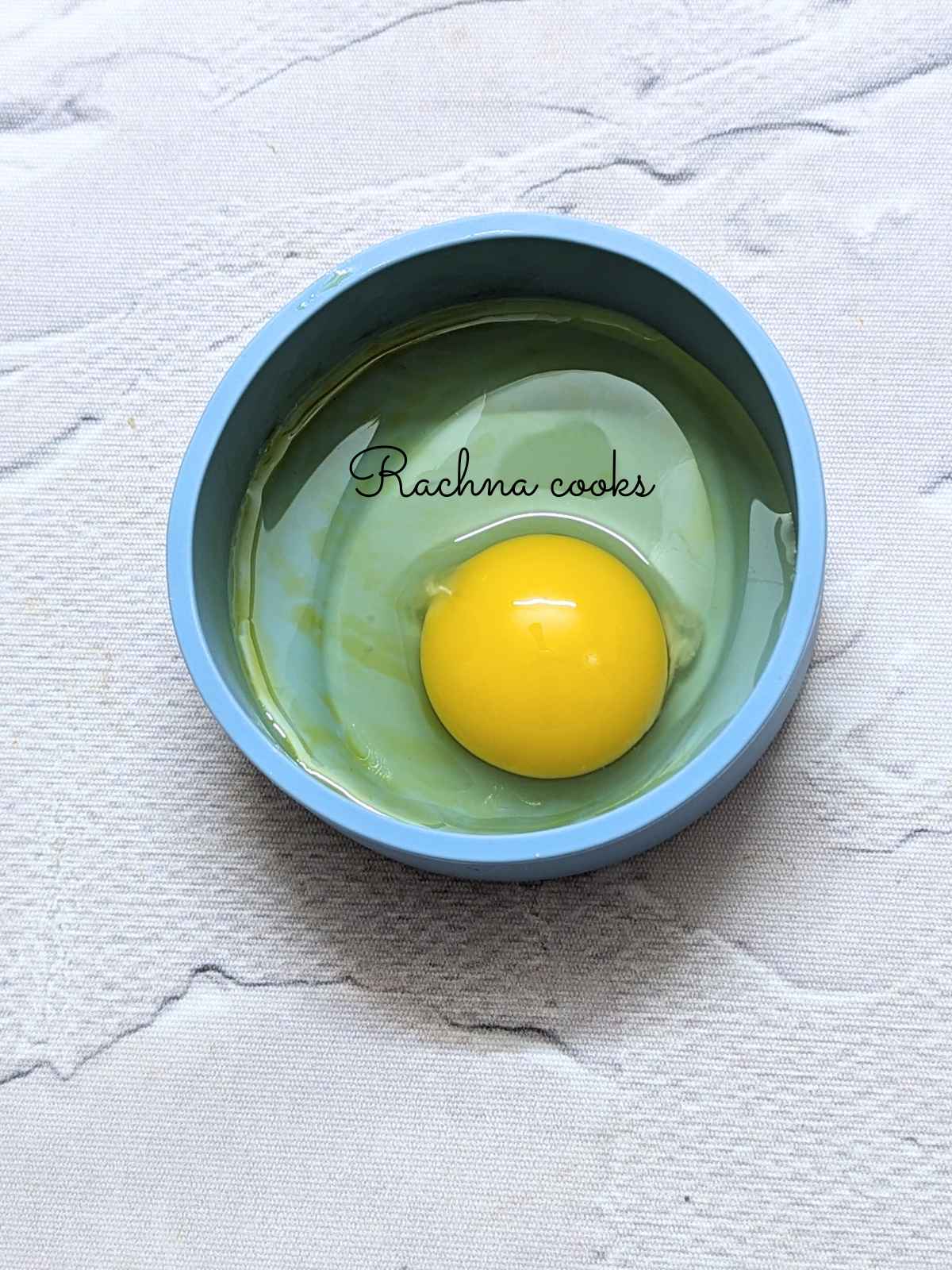Cracked egg inside an oiled silicone mold.