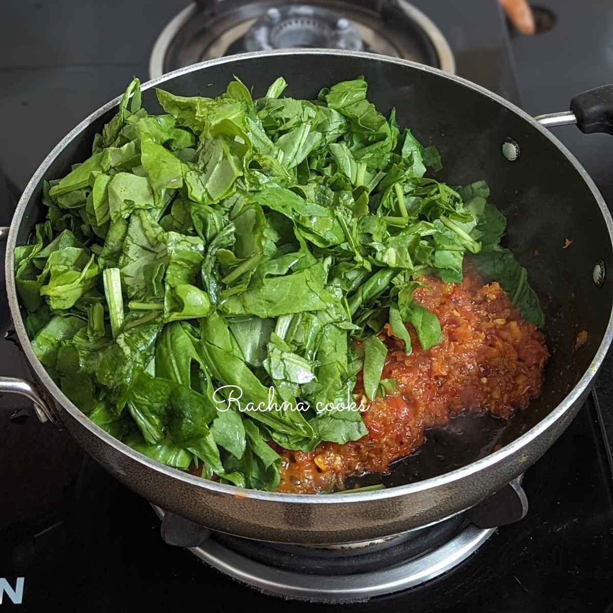 Chopped spinach added to the onion tomato mash