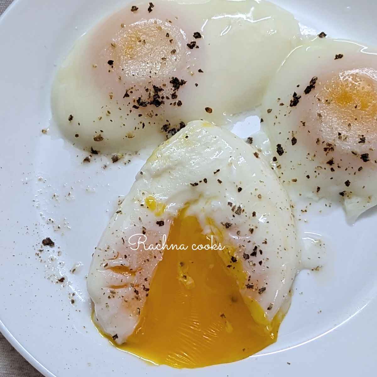 3 poached eggs on a plate with a broken yolk,