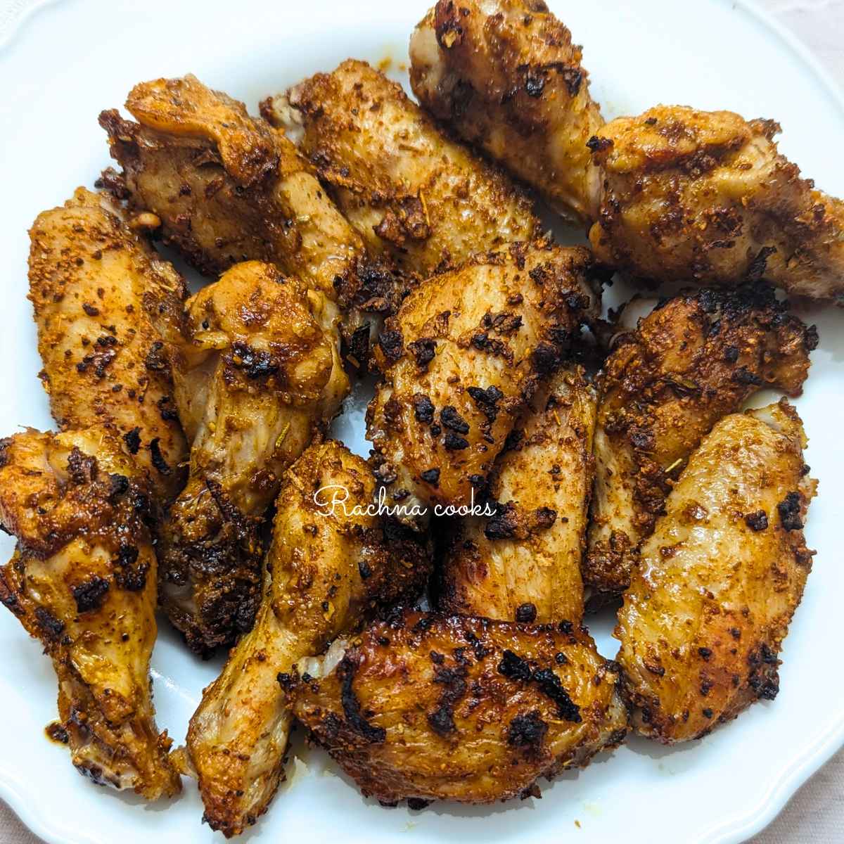 Jerk chicken wings after air frying on a white plate.