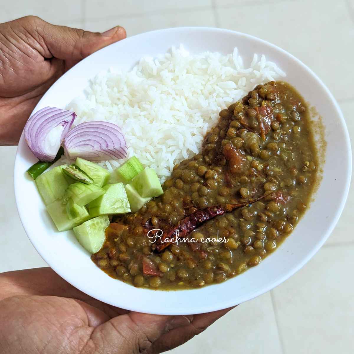 A bowl of sabut masoor dal served with boiled rice and a salad.