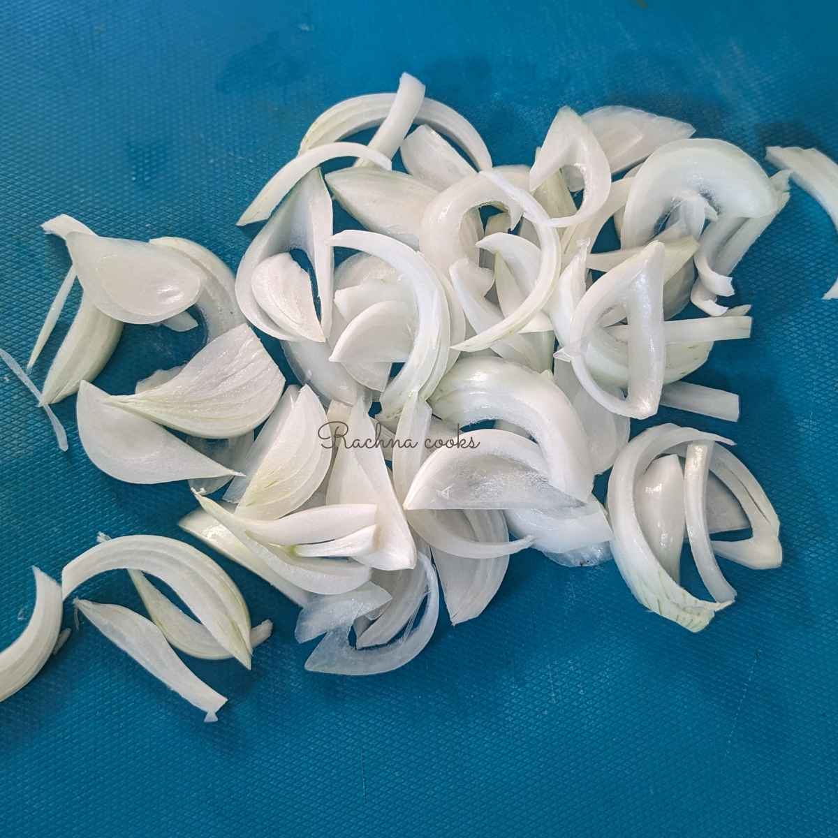 White onion slices on a chopping board.