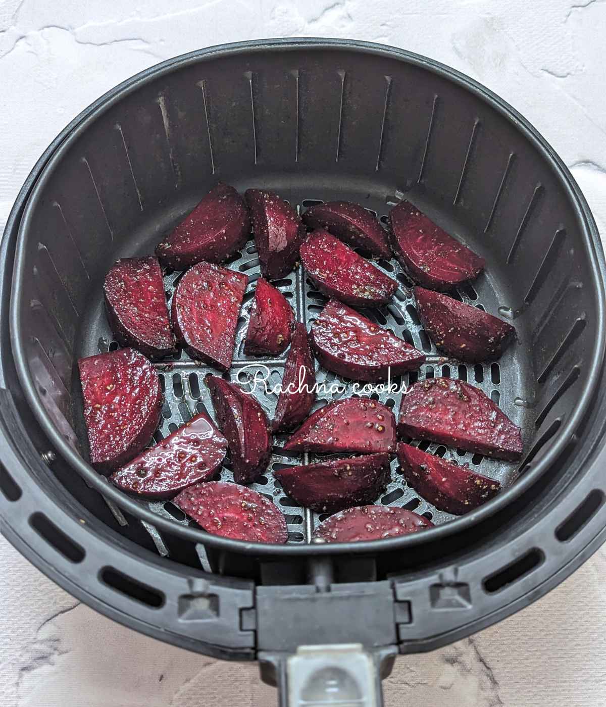 Seasoned beet wedges placed in air fryer basket.