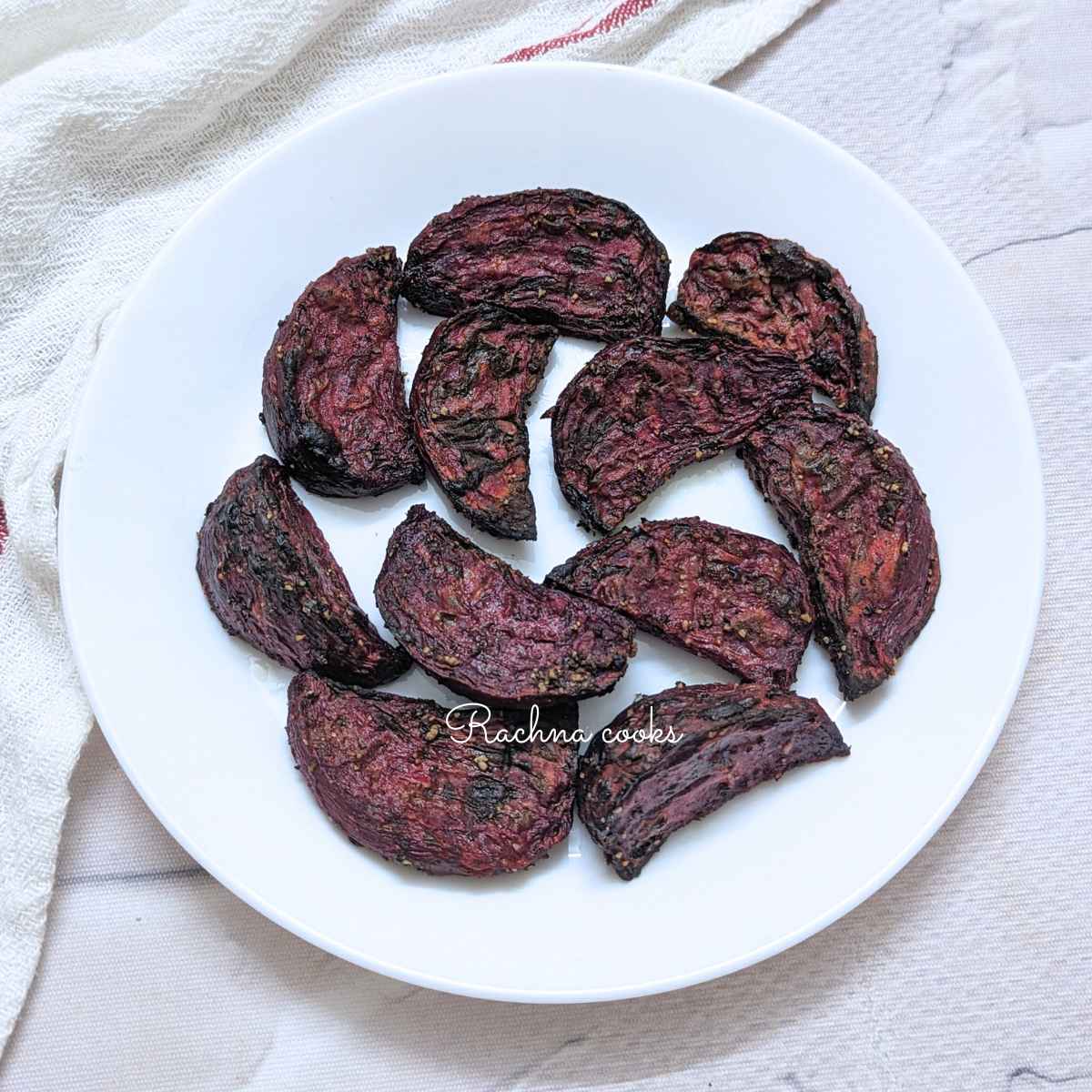 Roasted beets served on a white plate.