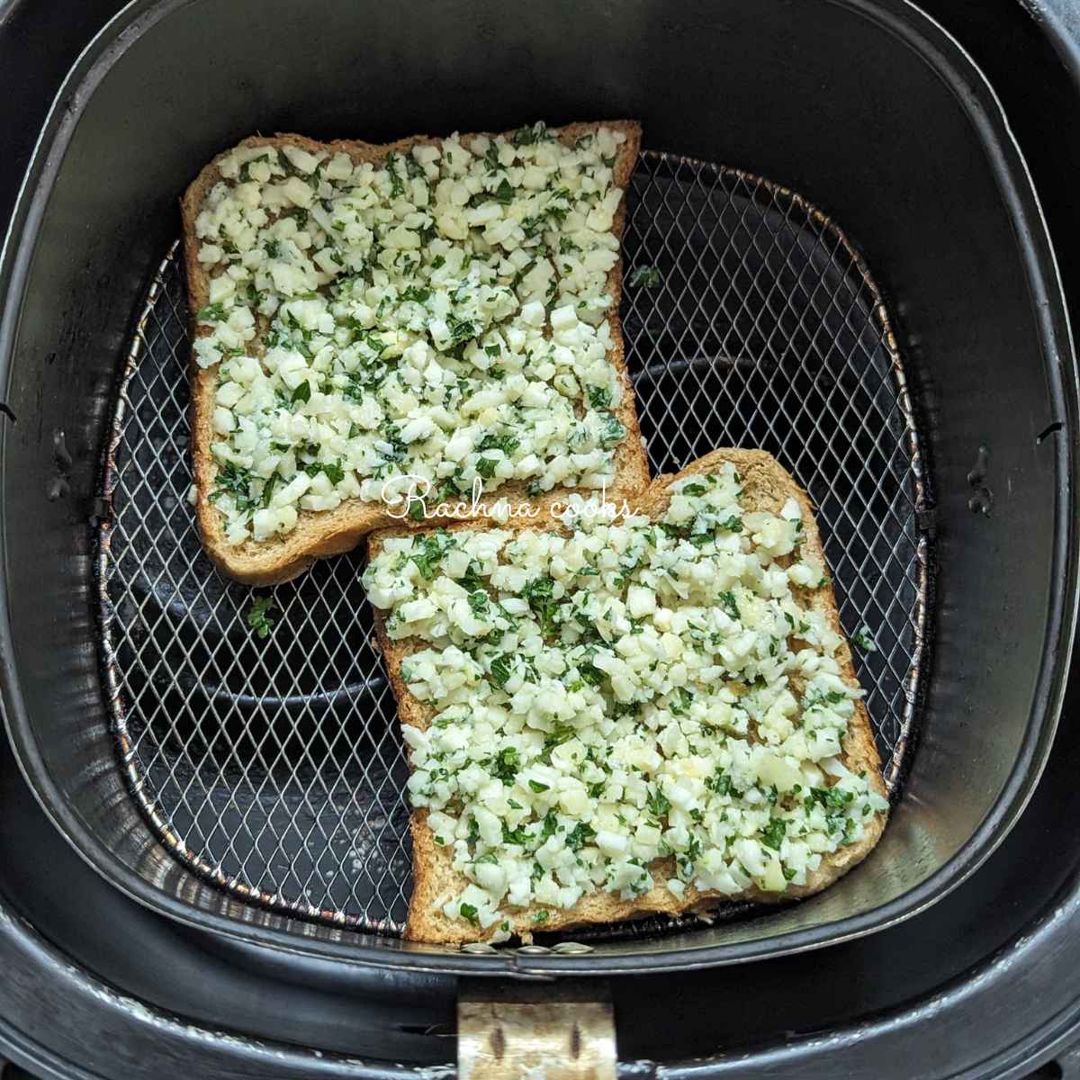 2 slices of garlic bread placed in air fryer basket.