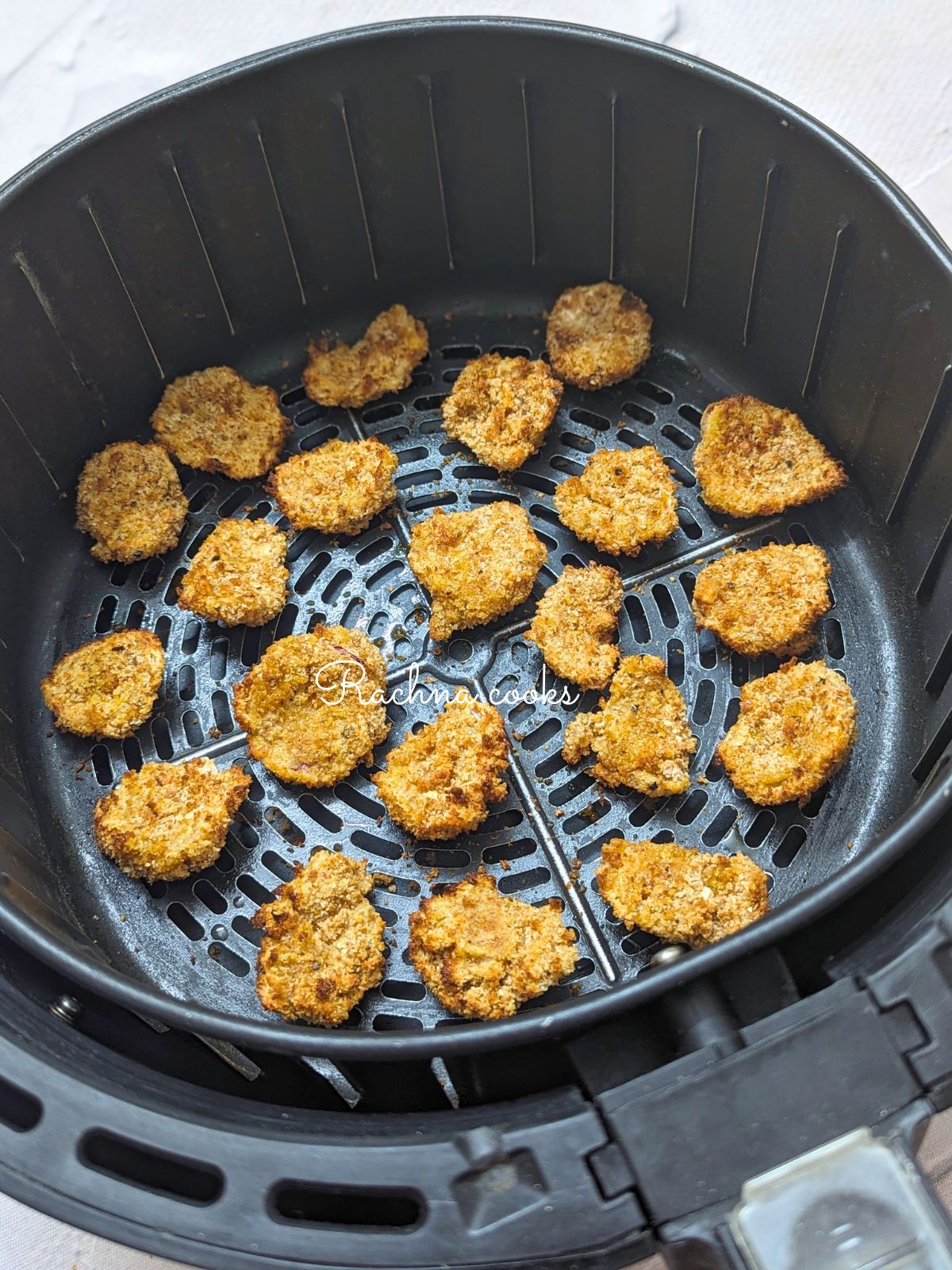 Crunchy onion petals after air frying in air fryer basket.