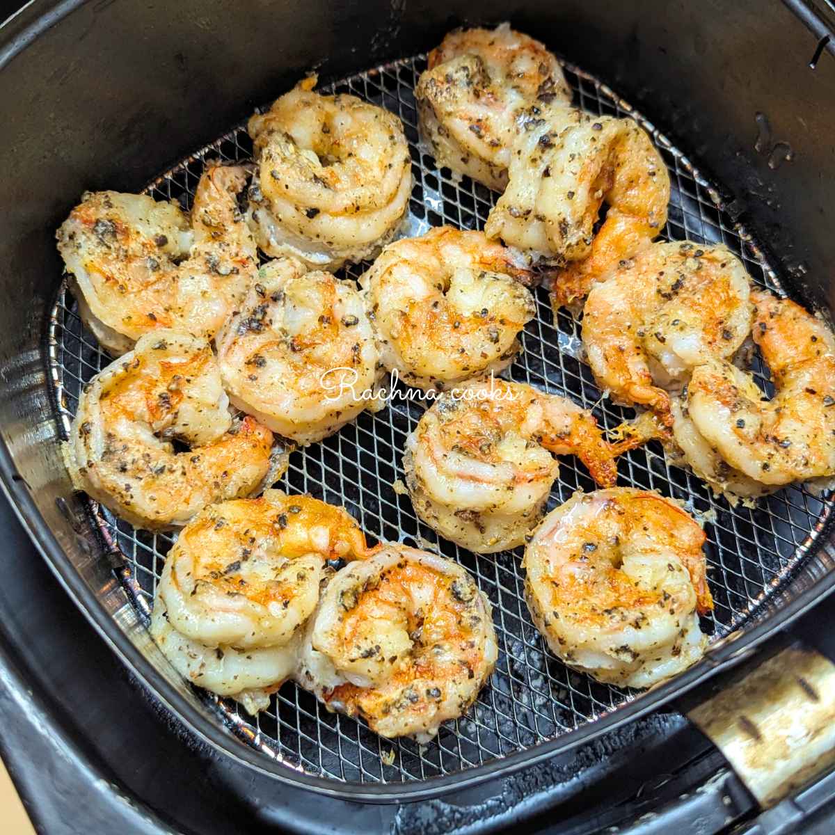 Crunchy salt and pepper shrimp in air fryer basket after air frying.