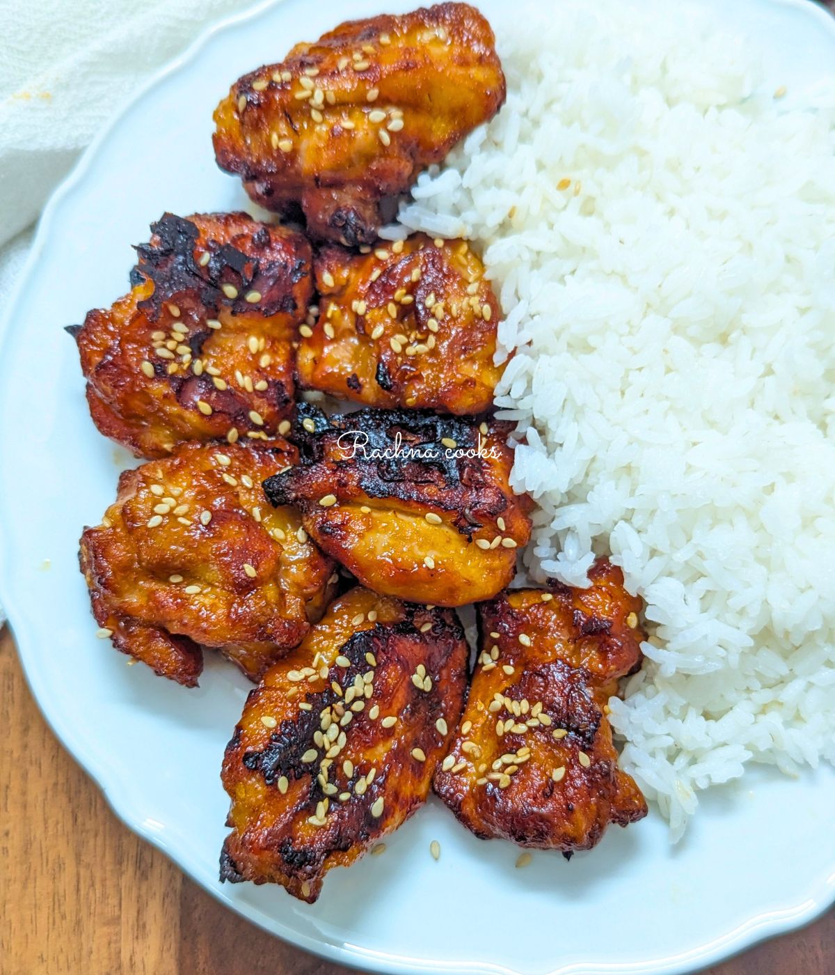 teriyaki chicken bites served with rice on a plate.