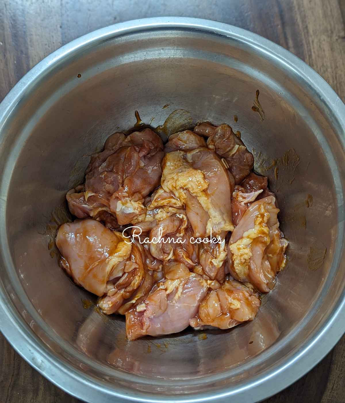 Chicken thighs marinated in teriyaki sauce in a bowl.