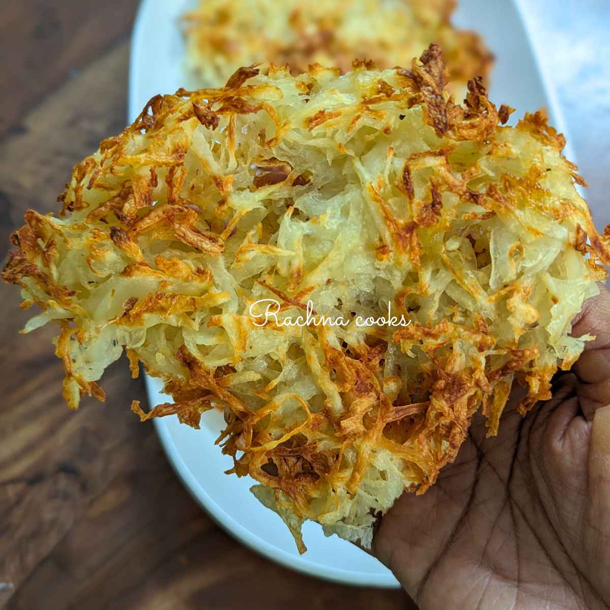Delicious crispy shredded hash brown after air frying held up in hand.