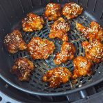 Teriyaki cauliflower bites after air frying in air fryer basket.