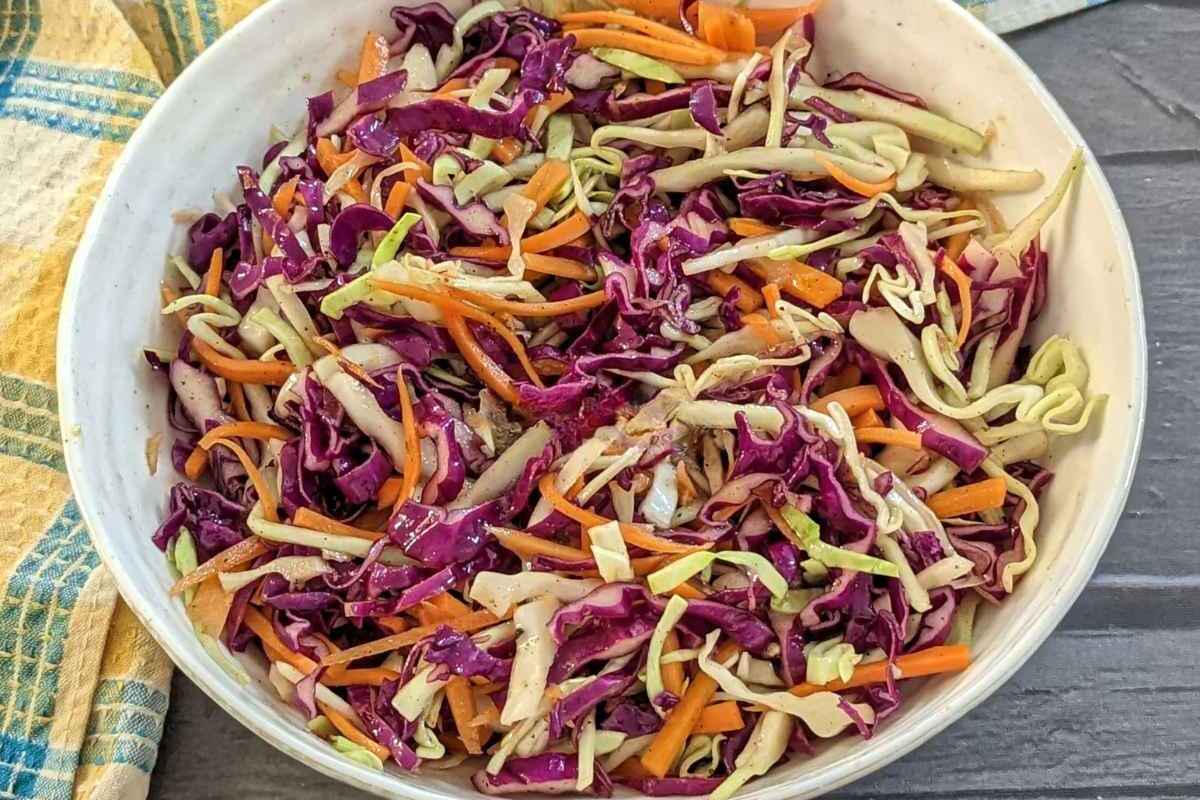Cabbage and carrot slaw served in a white bowl